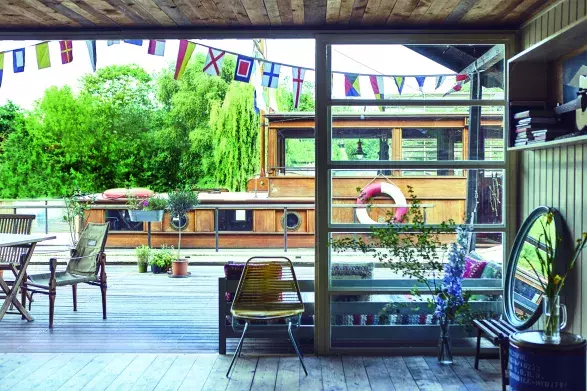 Z terasy chaty u Vltavy se dá rovnou nastoupit na loď, ale většinou se tady sedí. Třeba na klasickém skládacím plátěném safari křesílku Roorkhee od Melvill & Moon z roku 1898, které se objevilo ve filmu Vzpomínky na Afriku a používali je i britští armádní důstojníci při cestování v tropech. Uvnitř je jedna z českých židlí ze 60. let minulého století nalezených v kontejneru s odpadem, vlastnoručně  natřená původním kladívkovým lakem. Celá přední stěna je prosklená a dá se doširoka otevřít. Sjednocené plochy 