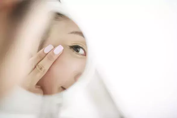woman looking at self in mirror