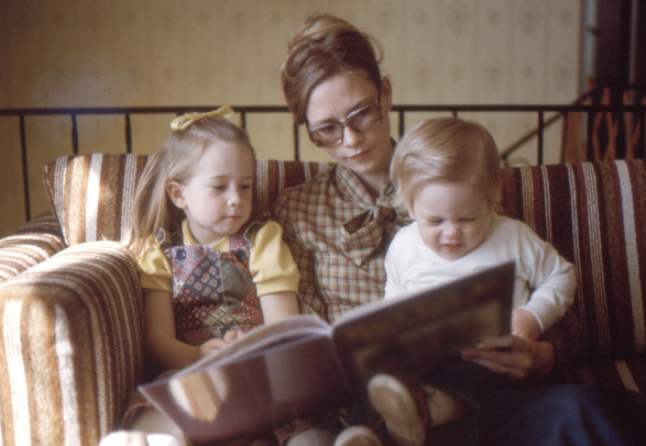 Mom and her little kids looking book
