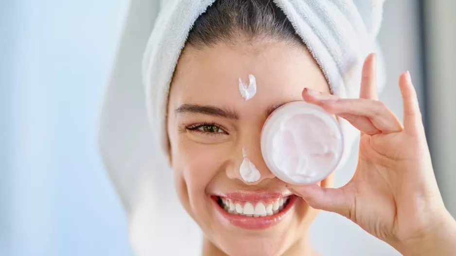 young woman applying moisturizer