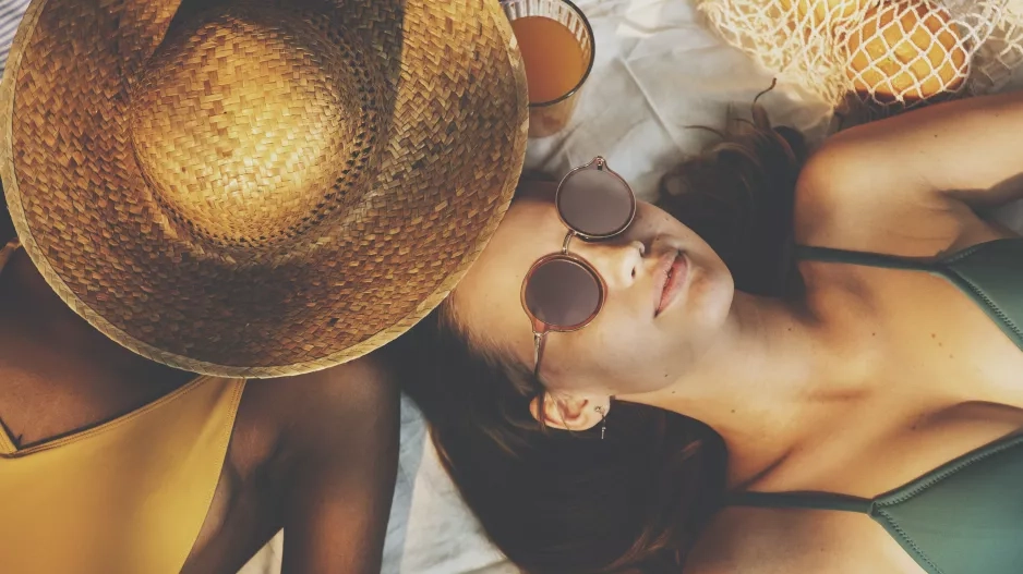 girls in swimsuit sun tanning together