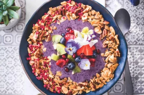 Miska s borůvkovým smoothie a granolou